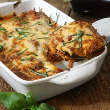 Baked eggplant parmesan being served with a metal spatula