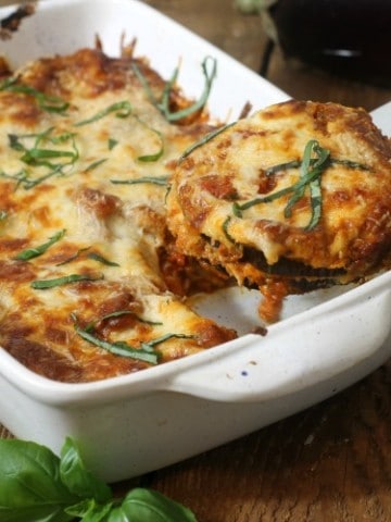 Baked eggplant parmesan being served with a metal spatula