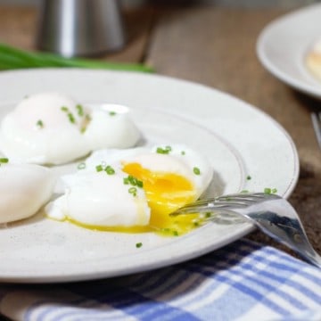 cut open poached eggs on a breakfast plate