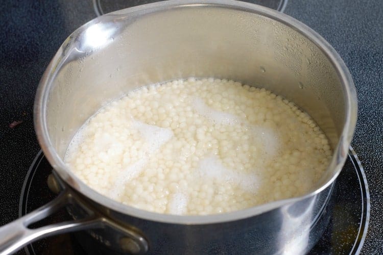 Israelicouscou also called pear couscous cooking in water on the stove.