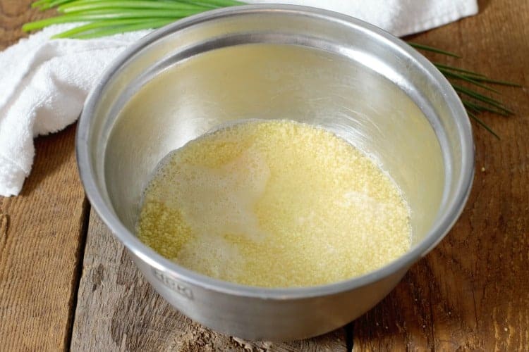 boiling water added to a stainless steel bowl of  raw couscous