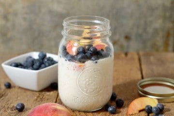 a close up shot of overnight oats made with greek yogurt and topped with fresh fruit