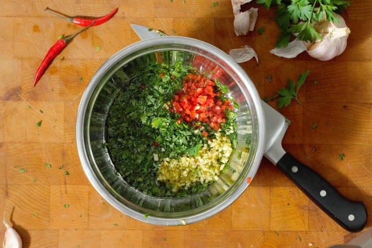 ingredients for chimichurri in a steel bowl before mixing