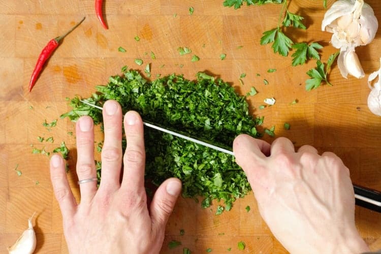 over head view of parsley being chopped very finely