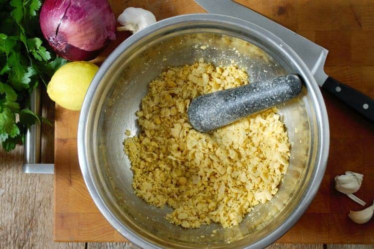 canned chickpeas crushed in a bowl with a pestle