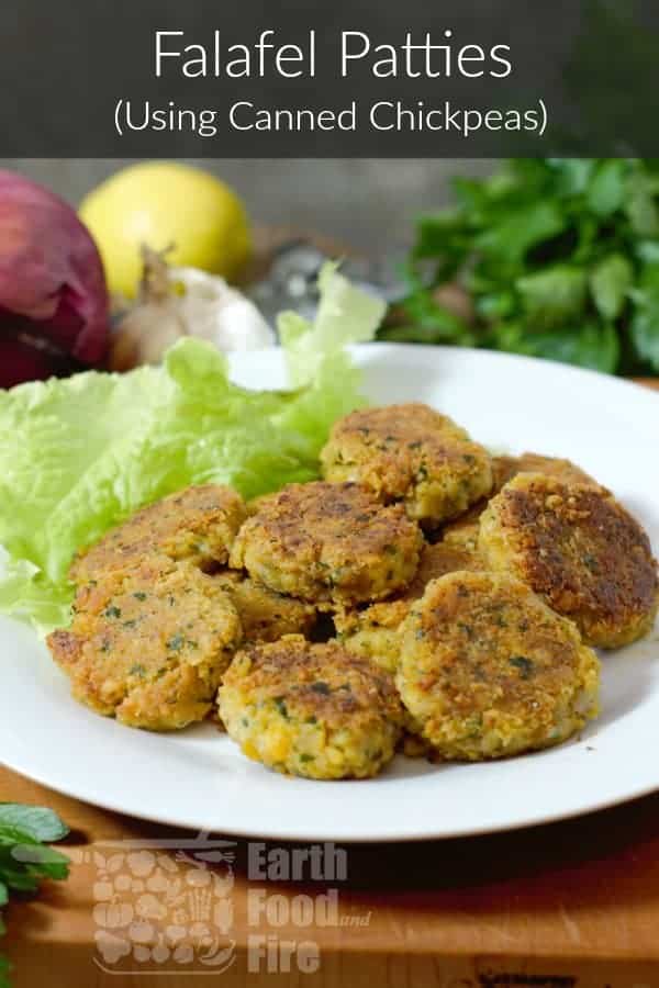 homemade falafel patties (made using canned chickpeas), on a white plate surrounded by various garnishes