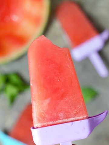 Homemade watermelon popsicle with a bite out of one corner