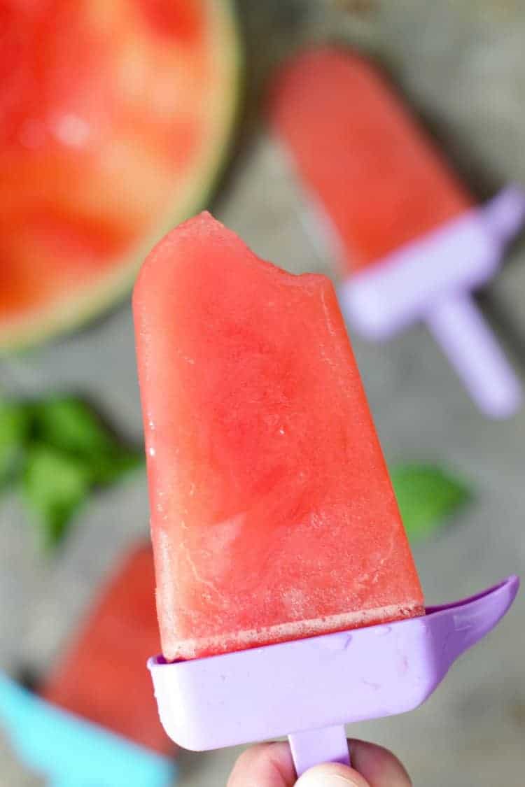 Homemade watermelon popsicle with a bite out of one corner