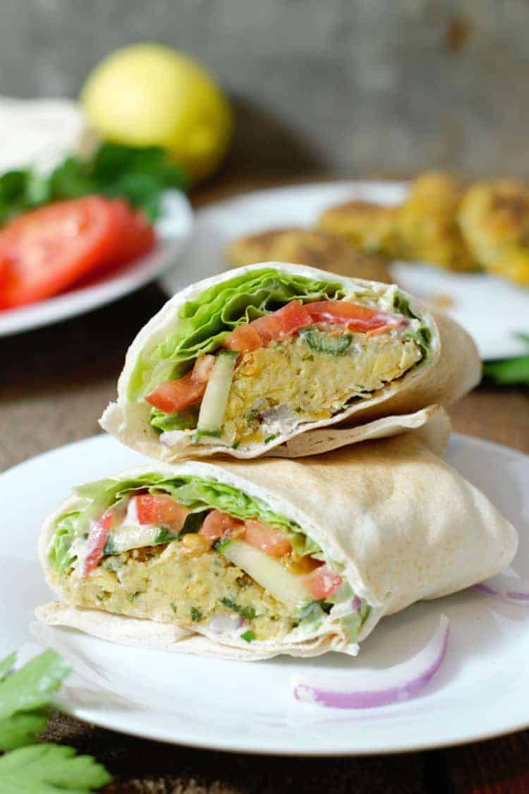 vertical image of a freshly made falafel wrap ready to be eaten