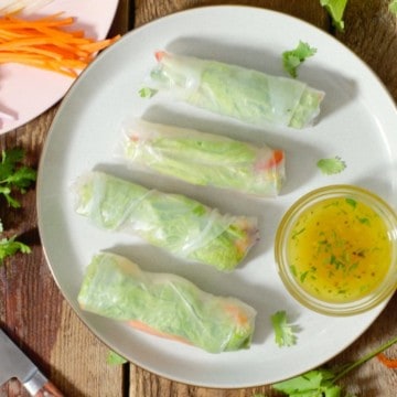 rice paper rolls arranged on a plate around a thai dipping sauce