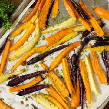 oven roasted baby carrots on a sheetpan garnished with chives