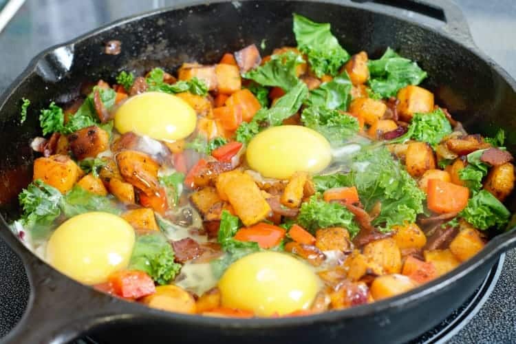 adding eggs to the sweet potato hash