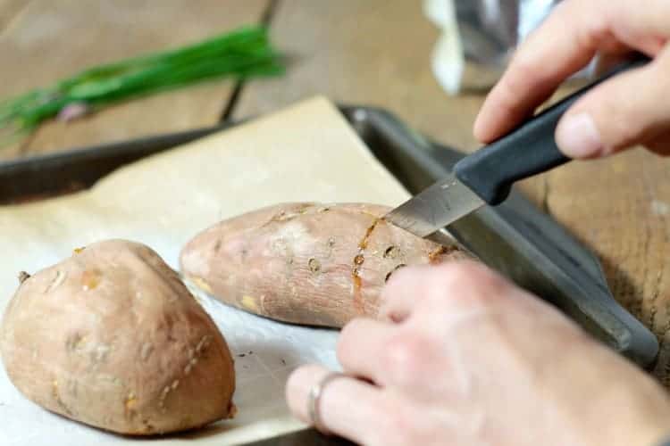 cutting a baked sweet potato with a small paring knife