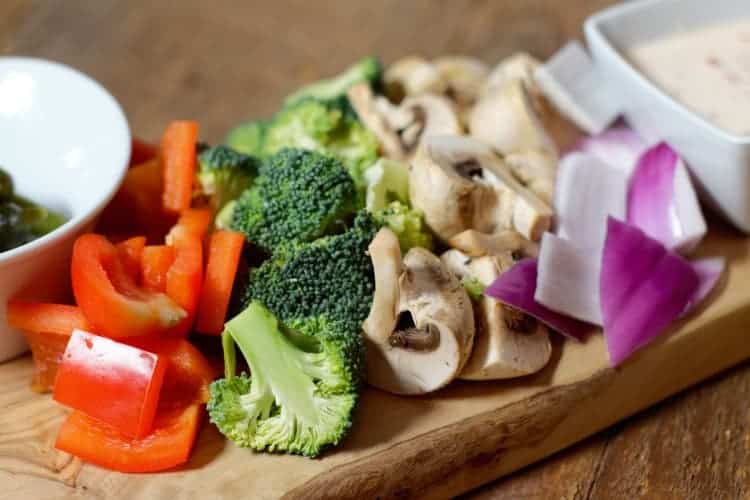 a selection of raw vegetables cut into bite sized pieces for a meat fondue