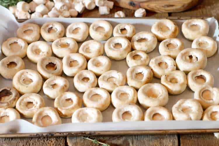 placing button mushrooms on a roasting tray