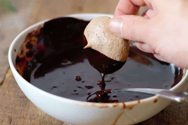 dipping chocolate meringue cookies in melted chocolate