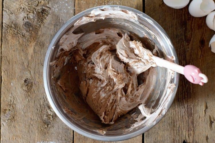 folding cocoa powder into the meringue mixture