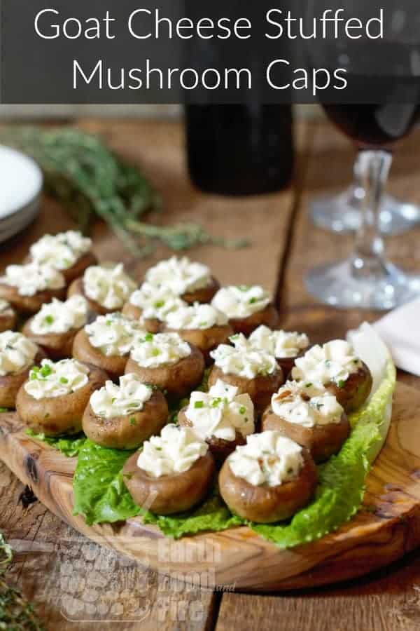 goat cheese stuffed mushroom caps displayed on a wooden serving board