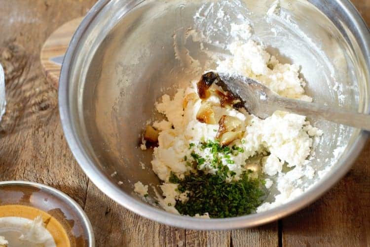 mixing roasted garlic, herbs, and spices into goat cheese
