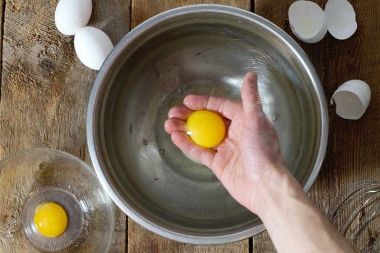 seperating egg yolks from egg white in a metal bowl