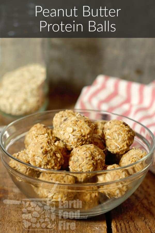 peanut butter protein balls in a glass bowl on a wood board tabletop