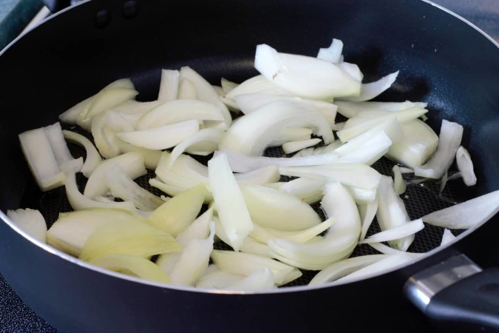 raw sliced onions in a pan