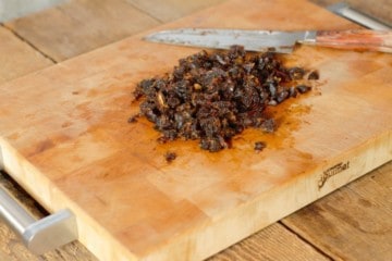 dried dates chopped on a wooden cutting board