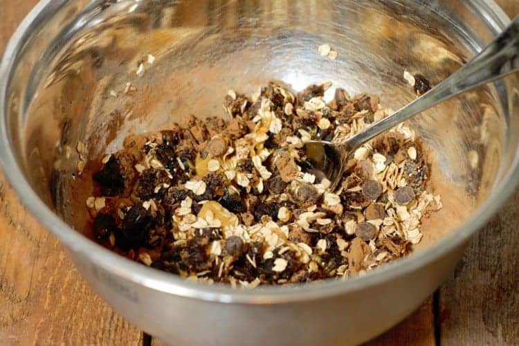 ingredients for chocolate date balls being mixed in a metal bowl