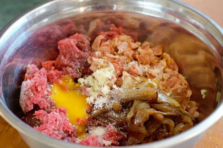 ingredients needed to make game meat burgers in a steel bowl before mixing