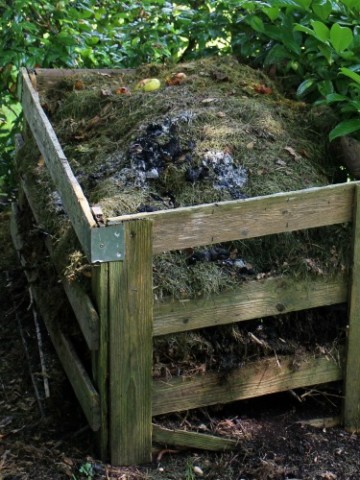 a wooden compost bin filled with rotting material.