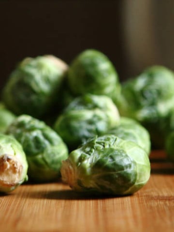 individual raw brussel sprouts on a wood surface