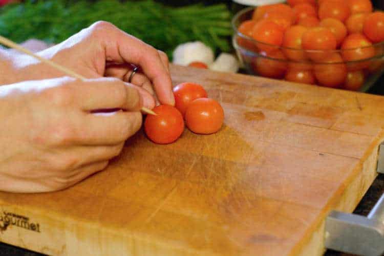 pricking cherry tomatoes with a toothpick prior to pickling