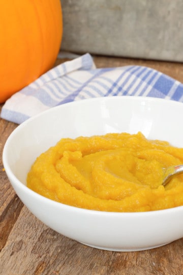 vertical picture of homemade pumpkin puree in a white bowl