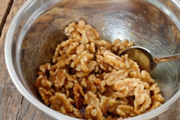 mixing the walnuts and maple syrup with a spoon