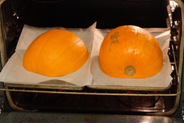 pumpkin cut in half on sheetpans ready to be roasted