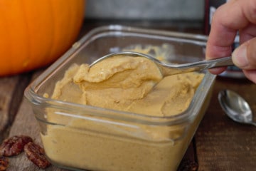 ice cream being scooped out of a glass container