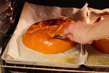 checking the roasted pumpkin for doneness with a fork