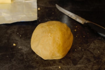 a smooth ball of cookie dough on a dark counter