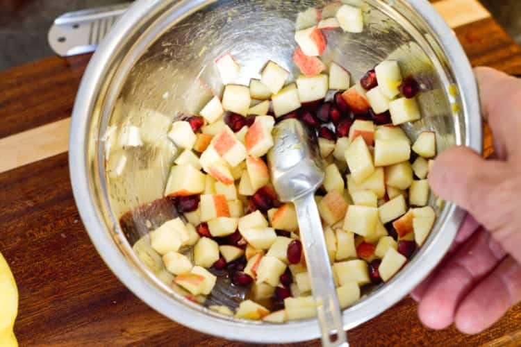 mixing the apple and pomegranate salad