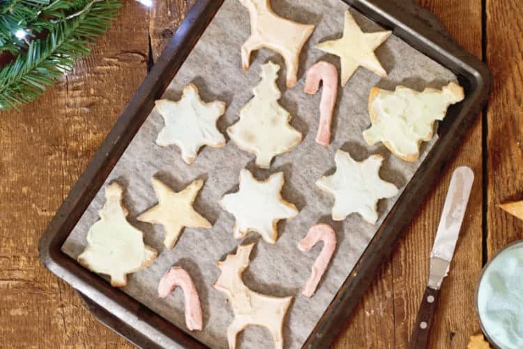 horizontal image of pastel coloureed sugar cookies on a baking tray