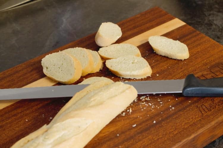 sliced baguette bread on a wooden cutting board