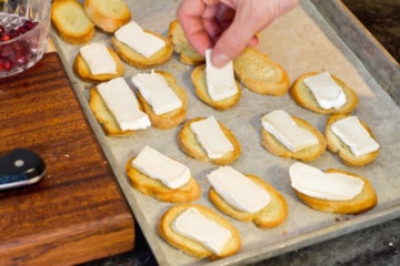 topping the crostini's with the sliced brie