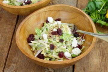 close up shot of the shaved brussels sprout salad in a wooden bowl