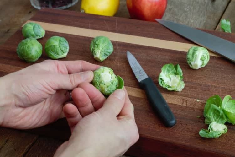 peeling the outer leaves away from the brussels sprout