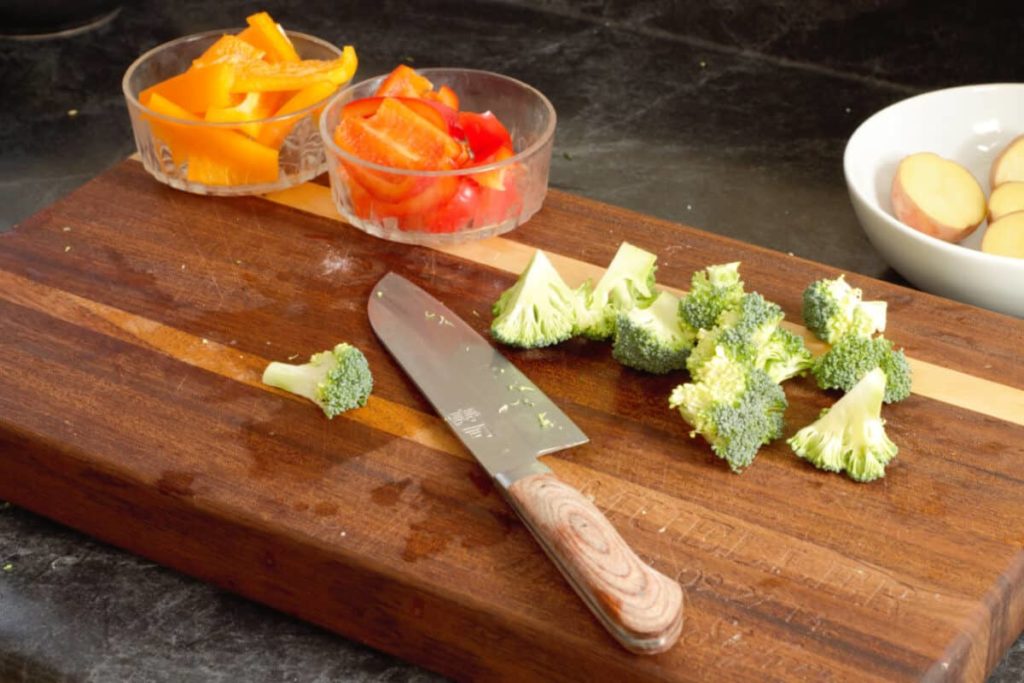preparing vegetables on a wooden cutting board