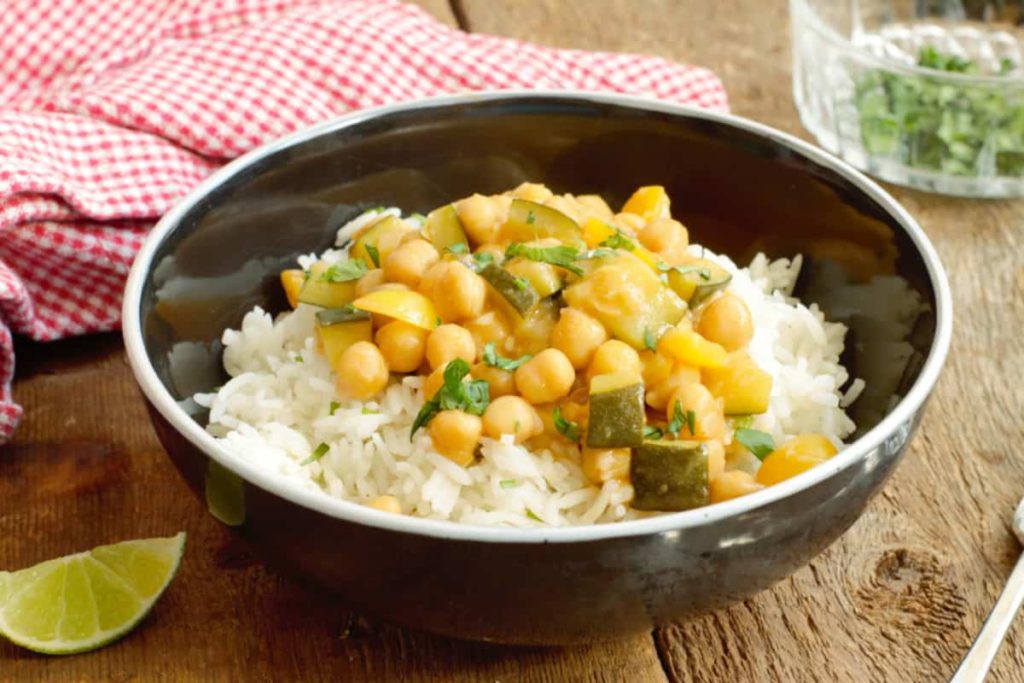 spiced chickpea curry served on basmati rice in a black bowl