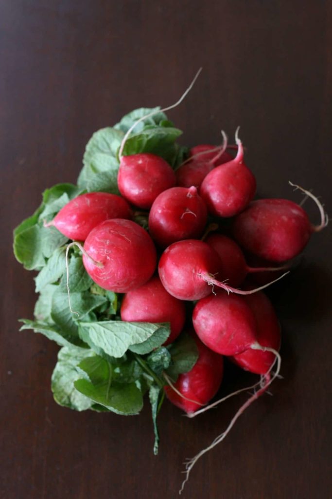 a close up of a bunch of small red radishes