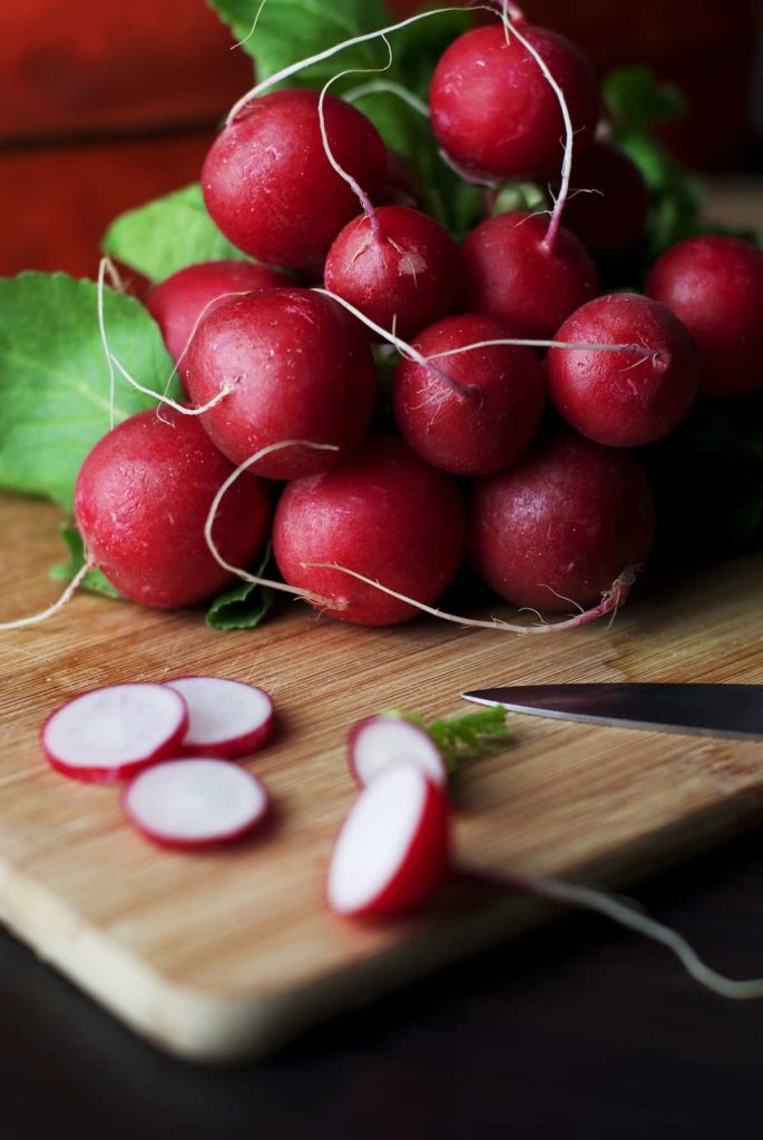 cherriette radishes on a cutting board being sliced