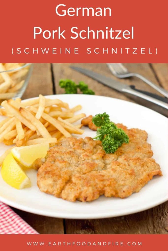 German pork schnitzel served on a white plate with pommes.