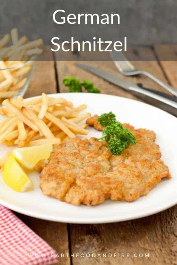 German schnitzel served alongside French fries, lemon, and parsley.